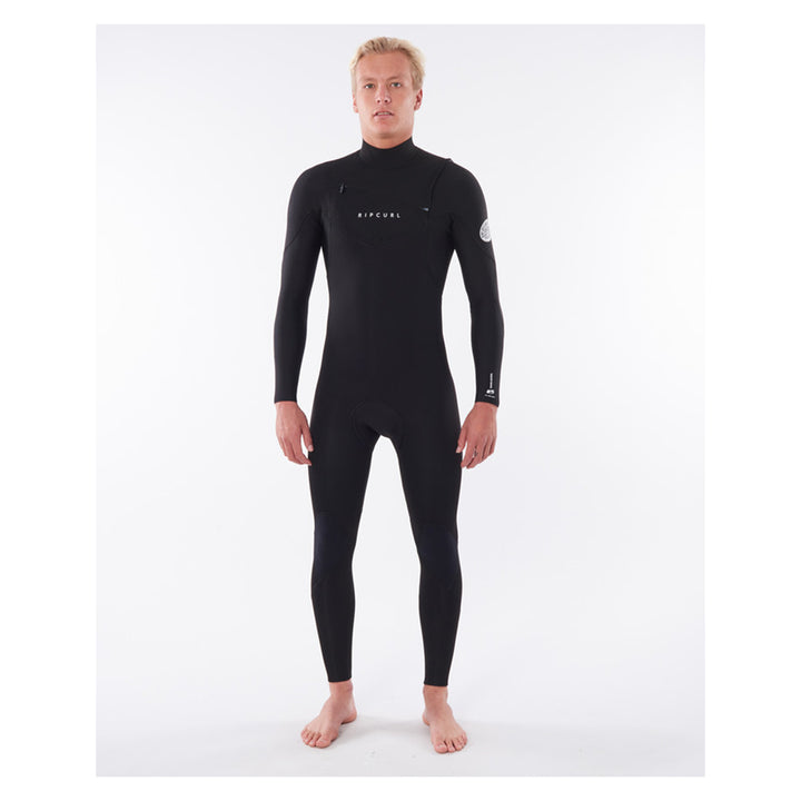 A male model wearing a black mens dawn patrol 5/3mm chest zip wetsuit with the brand name 'Rip Curl' on the chest.