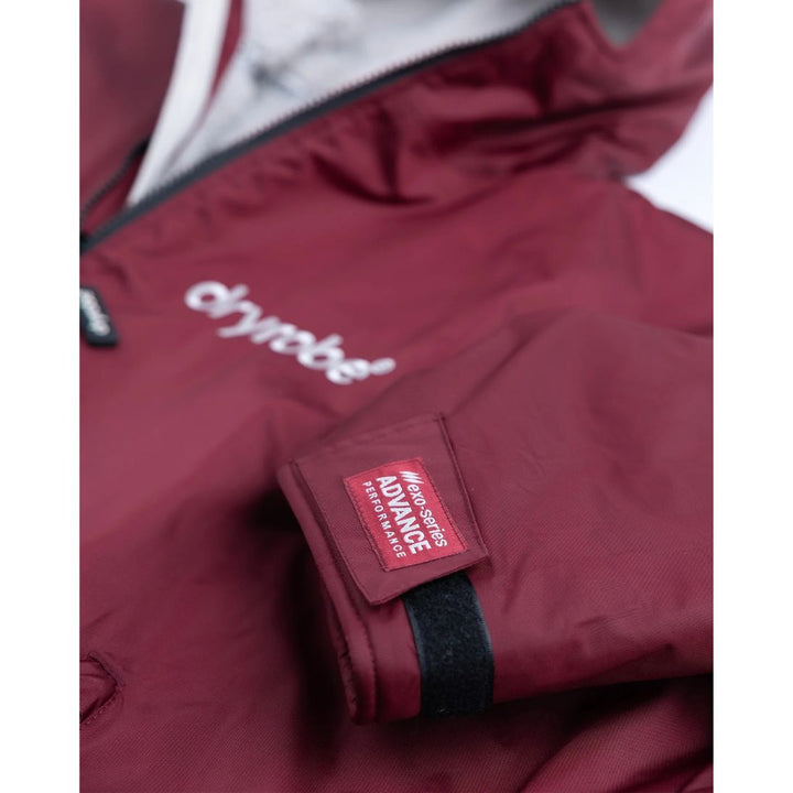 Close-up of a maroon jacket with a brand logo on a white background